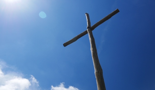 brown wooden cross on a hill
